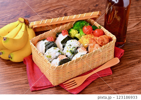 おにぎりのお弁当。しゃけ、野沢菜じゃこ、梅干し。唐揚げ、卵焼き、ブロッコリー、ミニトマト。 おにぎりのお弁当。しゃけ、野沢菜じゃこ、梅干し。唐揚げ、卵焼き、ブロッコリー、ミニトマト。 123186933