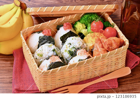 おにぎりのお弁当。しゃけ、野沢菜じゃこ、梅干し。唐揚げ、卵焼き、ブロッコリー、ミニトマト。 おにぎりのお弁当。しゃけ、野沢菜じゃこ、梅干し。唐揚げ、卵焼き、ブロッコリー、ミニトマト。 123186935