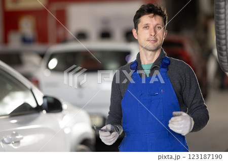 Service station man employee works in repair box, department 123187190