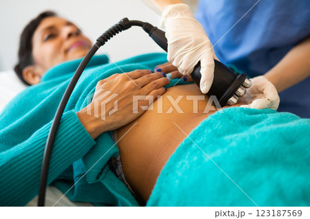 Cosmetologist making ultrasound lifting procedure in abdominal zones 123187569