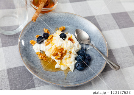 Farm cottage cheese filled with large amount of honey with walnut and blueberry. Farm cottage cheese filled with large amount of honey with walnut and blueberry. 123187628