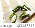 カッティングボードの上のさや入りグリーンピース 123187747