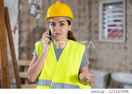 Woman builder talking on phone construction site 123187946
