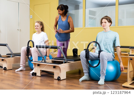 Pilates trainer teaching teens in gym 123187964
