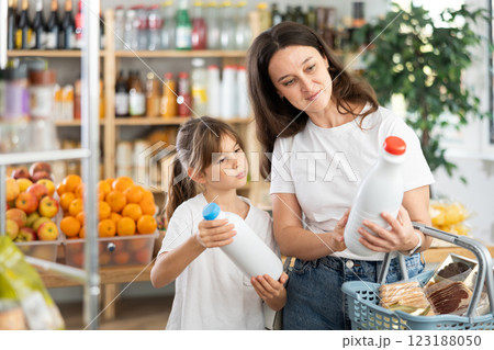 Checking expiration date of milk - mother and daughter checking qr code on bottle of milk Checking expiration date of milk - mother and daughter checking qr code on bottle of milk 123188050