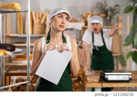 Young girl standing with her back to angry salesman pointing at the door 123188210