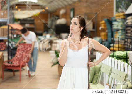 Thoughtful woman looking for furniture and accessories in garden store Thoughtful woman looking for furniture and accessories in garden store 123188213