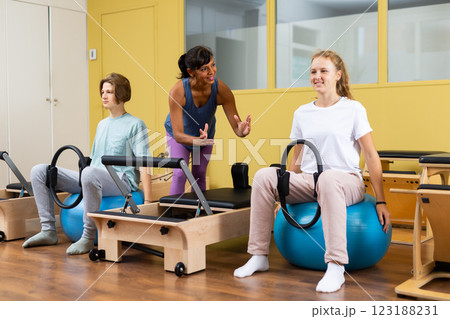 Pilates trainer teaching teens in gym Pilates trainer teaching teens in gym 123188231