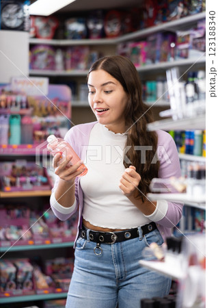 Young woman is choosing new conditioner in hair care store Young woman is choosing new conditioner in hair care store 123188340