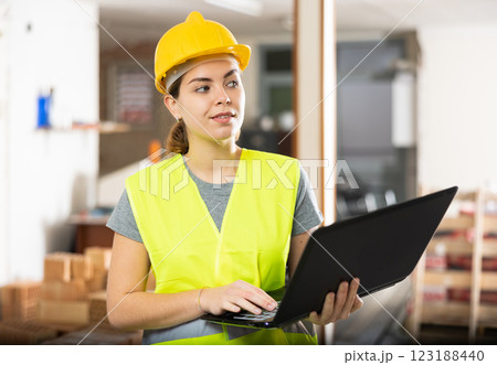 Woman with laptop on indoor construction site Woman with laptop on indoor construction site 123188440