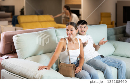 Young couple choosing convenient sofa in furniture shop 123188460