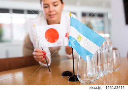 Unrecognizable girl sets midget flags of Argentina and Japan before international negotiations Unrecognizable girl sets midget flags of Argentina and Japan before international negotiations 123188615