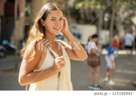 Portrait of a young girl in a light summer dress on city street during the day 123188942