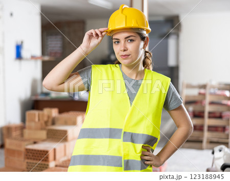 Smiling female civil engineer in yellow uniform at construction site 123188945