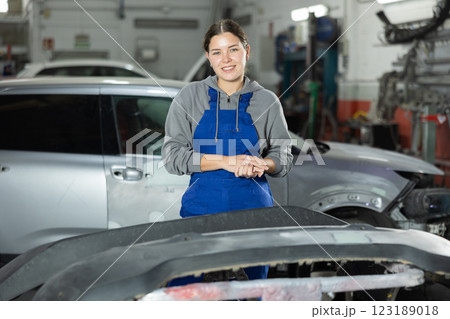 Young woman auto mechanic polishes body parts by car buffer polisher machine tool Young woman auto mechanic polishes body parts by car buffer polisher machine tool 123189018