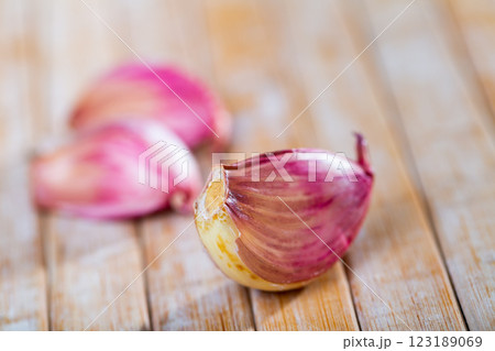Garlic cloves lie on a wooden surface 123189069