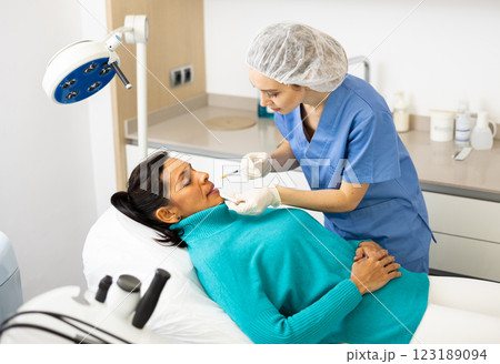 Woman receiving cosmetic facial injection at clinic Woman receiving cosmetic facial injection at clinic 123189094