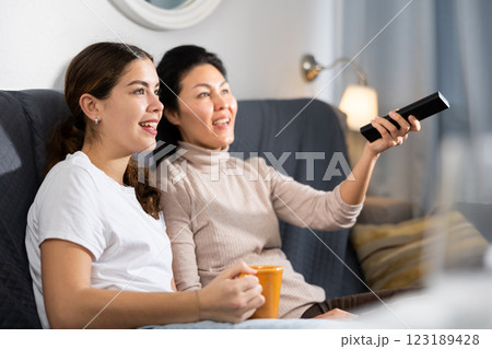 Two women relaxing at home watching TV 123189428