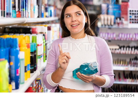 Young beautiful female shopper searching for mouthwashes Young beautiful female shopper searching for mouthwashes 123189554