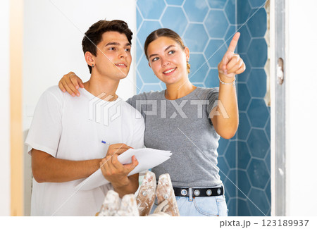 Interested couple making notes while planning overhaul of apartment 123189937