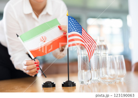 National flags of Iran and United States in hands of female office worker National flags of Iran and United States in hands of female office worker 123190063