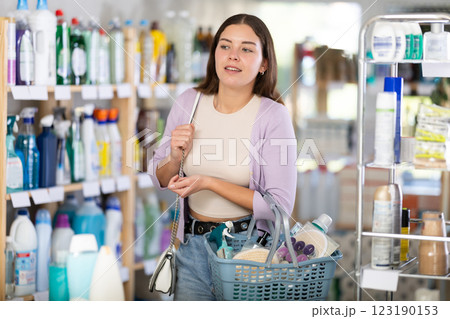 Young woman chooses household chemicals in store Young woman chooses household chemicals in store 123190153