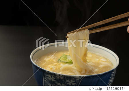 熱々のかきたまうどんを箸で持ち上げる 123190154