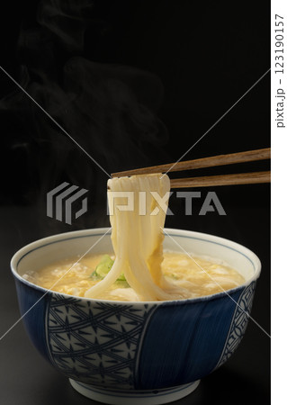 熱々のかきたまうどんを箸で持ち上げる 123190157