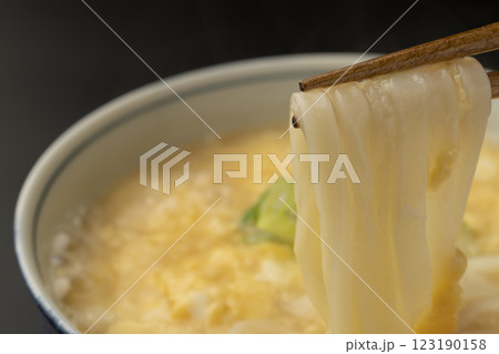熱々のかきたまうどんを箸で持ち上げる 123190158