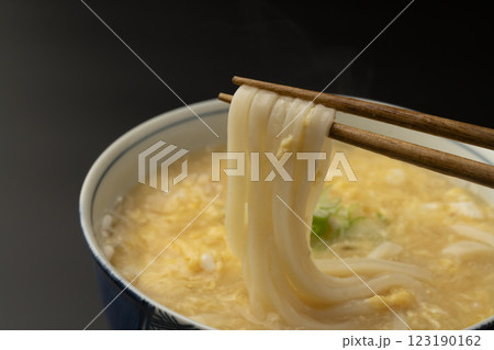 熱々のかきたまうどんを箸で持ち上げる 123190162