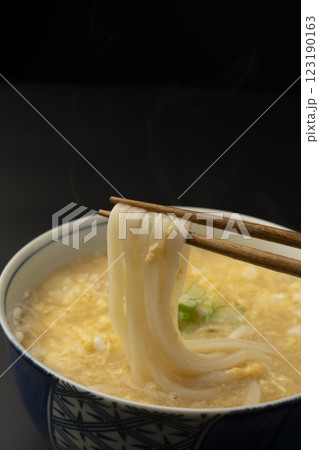 熱々のかきたまうどんを箸で持ち上げる 123190163