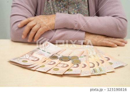 Retired Asian elderly woman counting coins money and worry about monthly expenses and treatment fee payment. 123190816