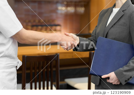 飲食店で握手をするビジネスウーマン 123190909