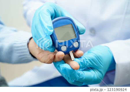 Asian doctor using digital glucose meter for check sample blood sugar level to treatment diabetes. Asian doctor using digital glucose meter for check sample blood sugar level to treatment diabetes. 123190924