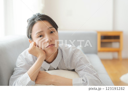 ソファに寝転んで悩む表情の女性 ソファに寝転んで悩む表情の女性 123191282