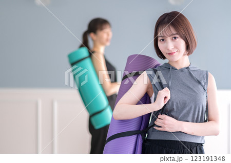ヨガマットを持つ笑顔の若い女性 ヨガマットを持つ笑顔の若い女性 123191348