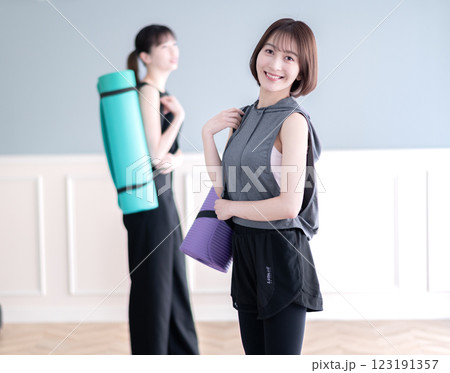 ヨガマットを持つ笑顔の若い女性 123191357
