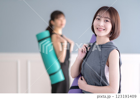 ヨガマットを持つ笑顔の若い女性 ヨガマットを持つ笑顔の若い女性 123191409