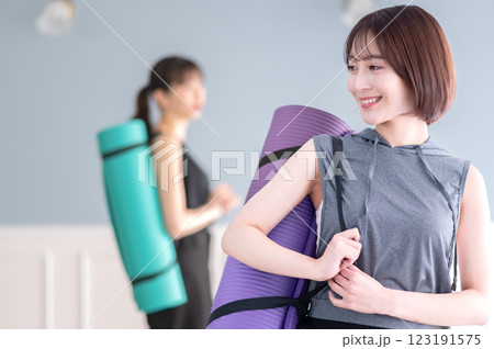 ヨガマットを持つ笑顔の若い女性 123191575