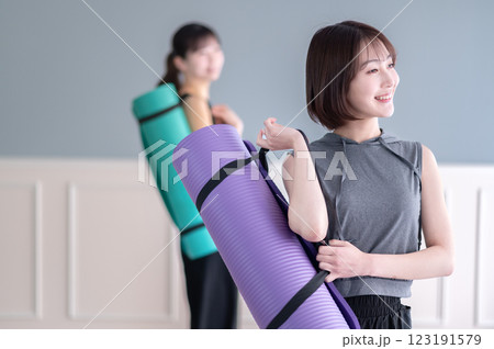 ヨガマットを持つ笑顔の若い女性 ヨガマットを持つ笑顔の若い女性 123191579