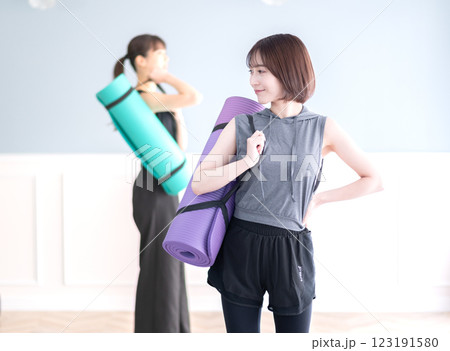ヨガマットを持つ笑顔の若い女性 ヨガマットを持つ笑顔の若い女性 123191580