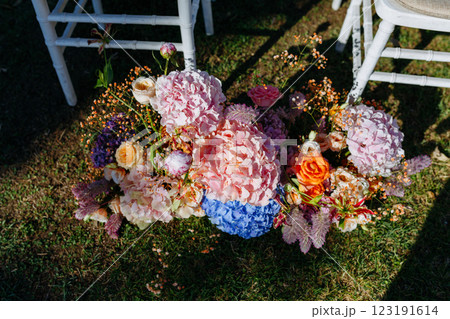 Flowers are on the ground in front of white chairs 123191614