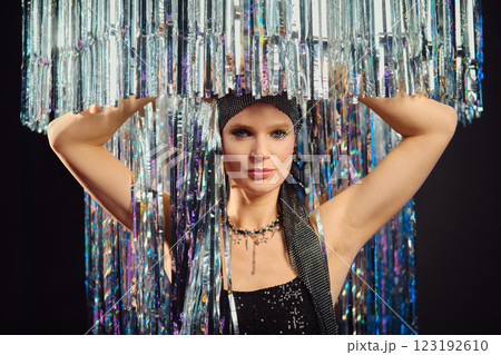 Elegant performer showcasing shimmering attire under sparkling light fixtures at a glamorous event 123192610