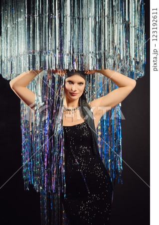 Model poses elegantly under a dazzling fringe installation at a fashion event Model poses elegantly under a dazzling fringe installation at a fashion event 123192611