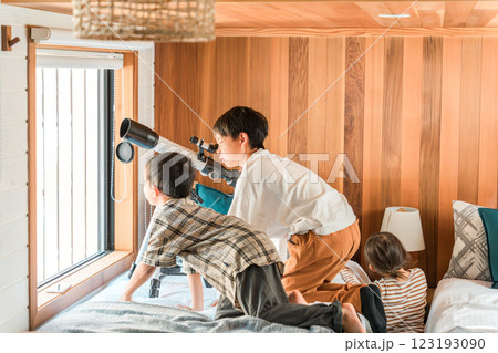 望遠鏡で遊ぶ夏休みの子供達・兄弟・兄妹(コテージ・別荘・山小屋・キャンプ・グランピング) 123193090