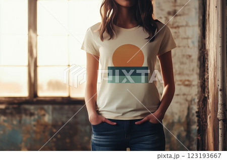 Young woman in casual attire showcasing sunset graphic on shirt in rustic indoor setting 123193667