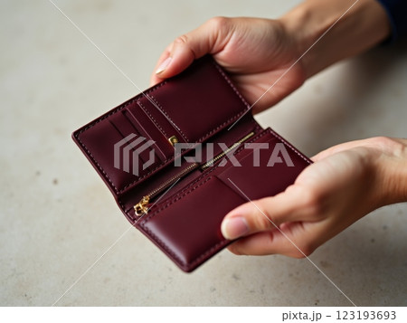 Elegant Feminine Hands Examining Designer Leather Wallet Against Polka Dot Background 123193693