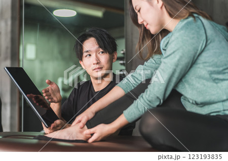 リハビリの相談をする困る・考える女性とメディカルトレーナー・柔道整復師の男性 リハビリの相談をする困る・考える女性とメディカルトレーナー・柔道整復師の男性 123193835