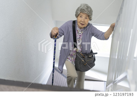 杖をつきながら階段をあがるシニア女性 123197193