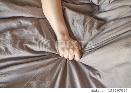 Close up of a person hand gripping grey wrinkled fabric with strength 123197955